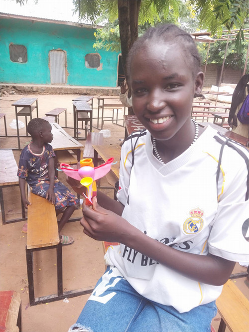 A child holding up a 3d printed educational model of a uterus.