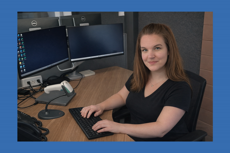 Student Elisha Muhleka sitting at an office computer.